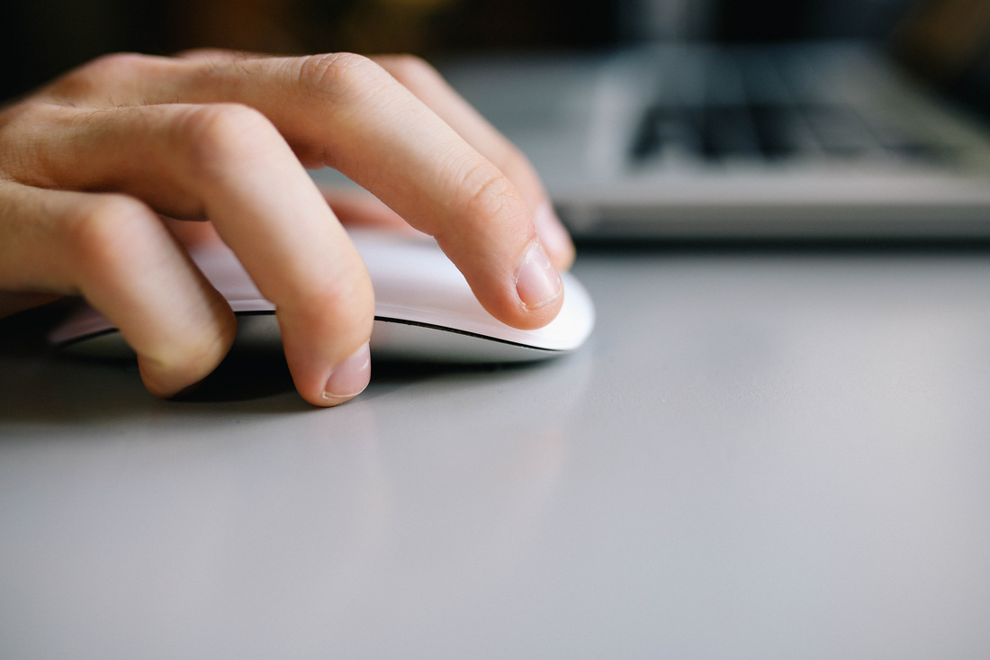 A hand using a computer mouse while preparing an abstract